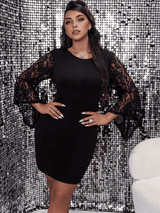 A woman in a black lace-sleeve dress stands with hands on hips.