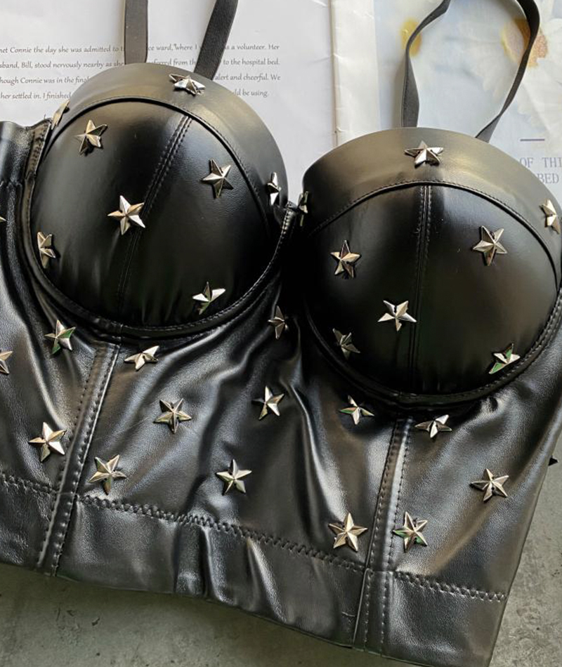 Close-up of the black leather bustier top, highlighting the silver star studs and the texture of the material.