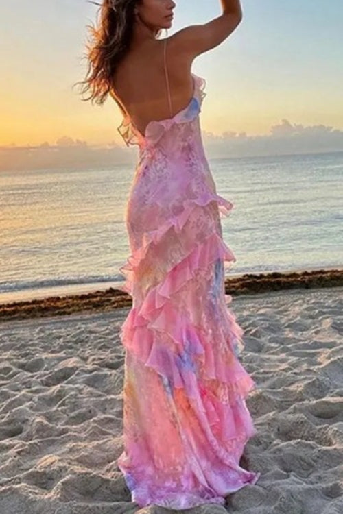Woman wearing a pink and blue tie-dye maxi dress with ruffles on the beach