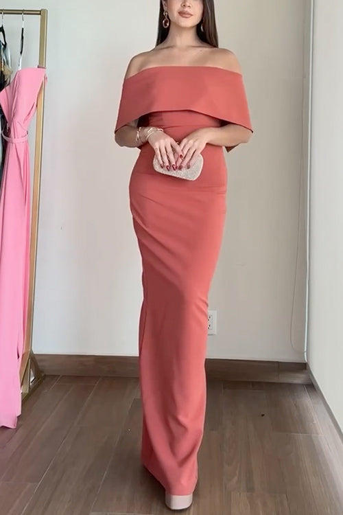 Woman holding a silver clutch while wearing a coral evening gown.