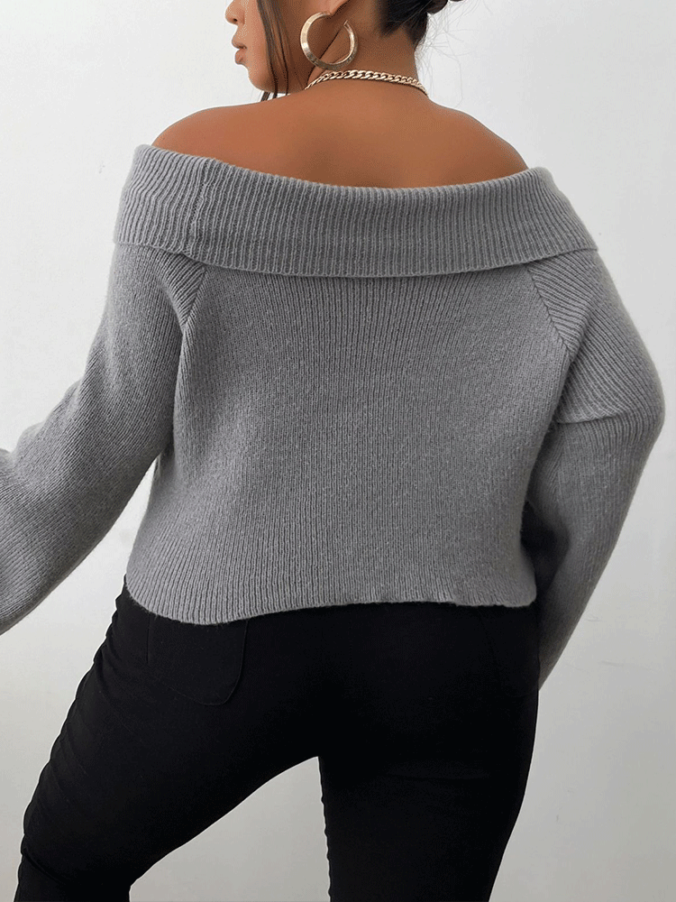 Back view of a woman wearing a gray off-the-shoulder sweater and black pants.