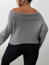 Back view of a woman wearing a gray off-the-shoulder sweater and black pants.