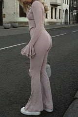 Side view of a woman wearing a pink long-sleeved top with flared sleeves and matching flare pants.