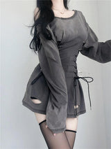 Woman posing in a gray off-the-shoulder dress with lace-up details and black thigh-high stockings.