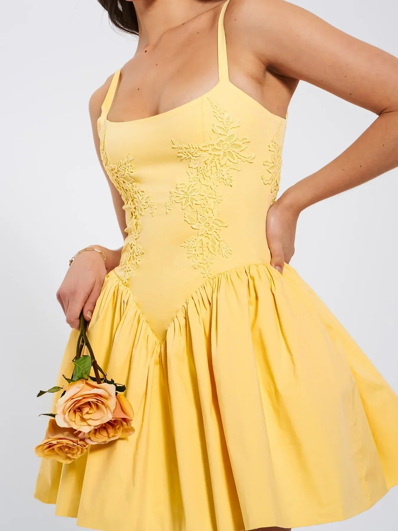 Close-up of a woman in a yellow dress holding roses