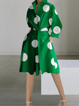A woman wearing a green polka dot shirt dress