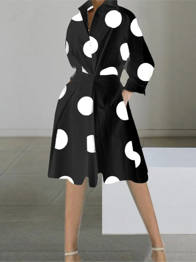A woman wearing a black polka dot shirt dress
