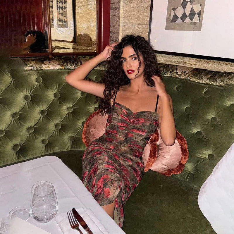 Woman with curly hair posing in a floral print ruched dress