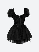 A black off-the-shoulder dress with puff sleeves, corset detailing, and a tiered skirt, displayed on a white background.