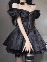 Woman wearing a short black off-the-shoulder dress with puff sleeves and a tiered skirt.
