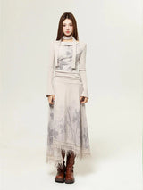 Woman wearing a beige long-sleeved dress with a floral print and a layered top, showcasing the front view and brown boots.