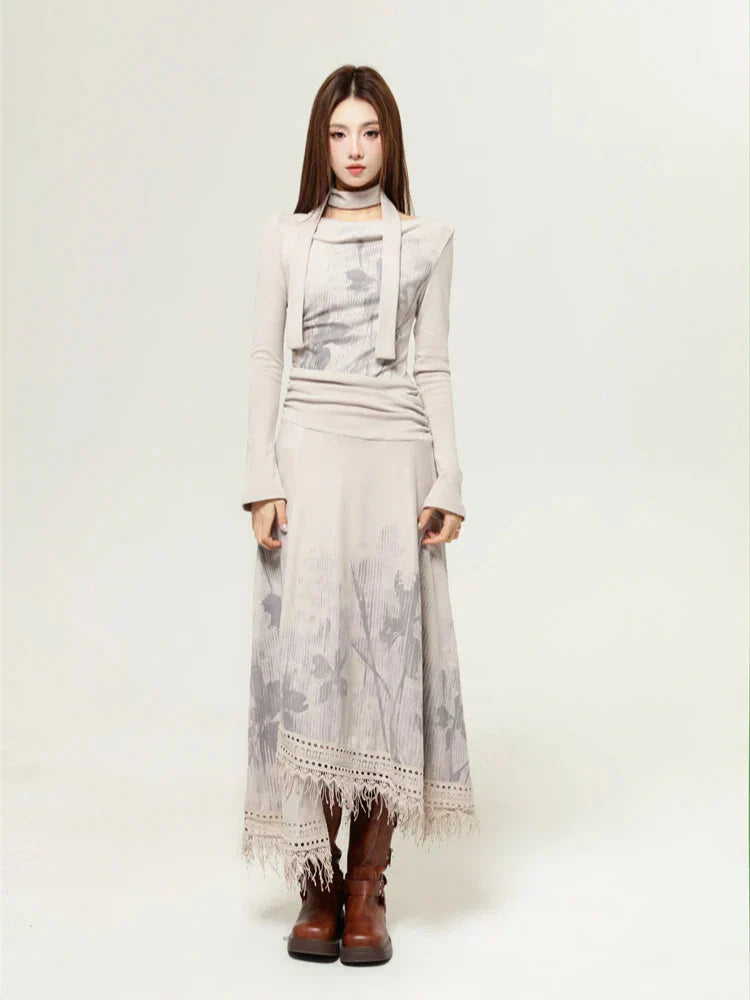 Woman wearing a beige long-sleeved dress with a floral print and a layered top, showcasing the front view and brown boots.