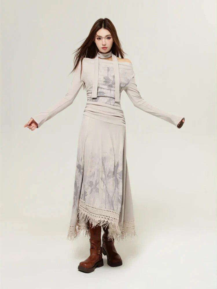 Woman in a beige long-sleeved dress with a floral print and a layered top, arms outstretched, paired with brown boots.