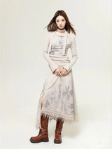 Woman wearing a beige long-sleeved dress with a floral print and a layered top, paired with brown boots.