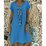 woman wearing a blue short-sleeve v-neck dress with a long tassel necklace