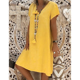 woman wearing a yellow short-sleeve v-neck dress with a long tassel necklace