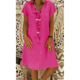 woman wearing a pink short-sleeve v-neck dress with a long tassel necklace