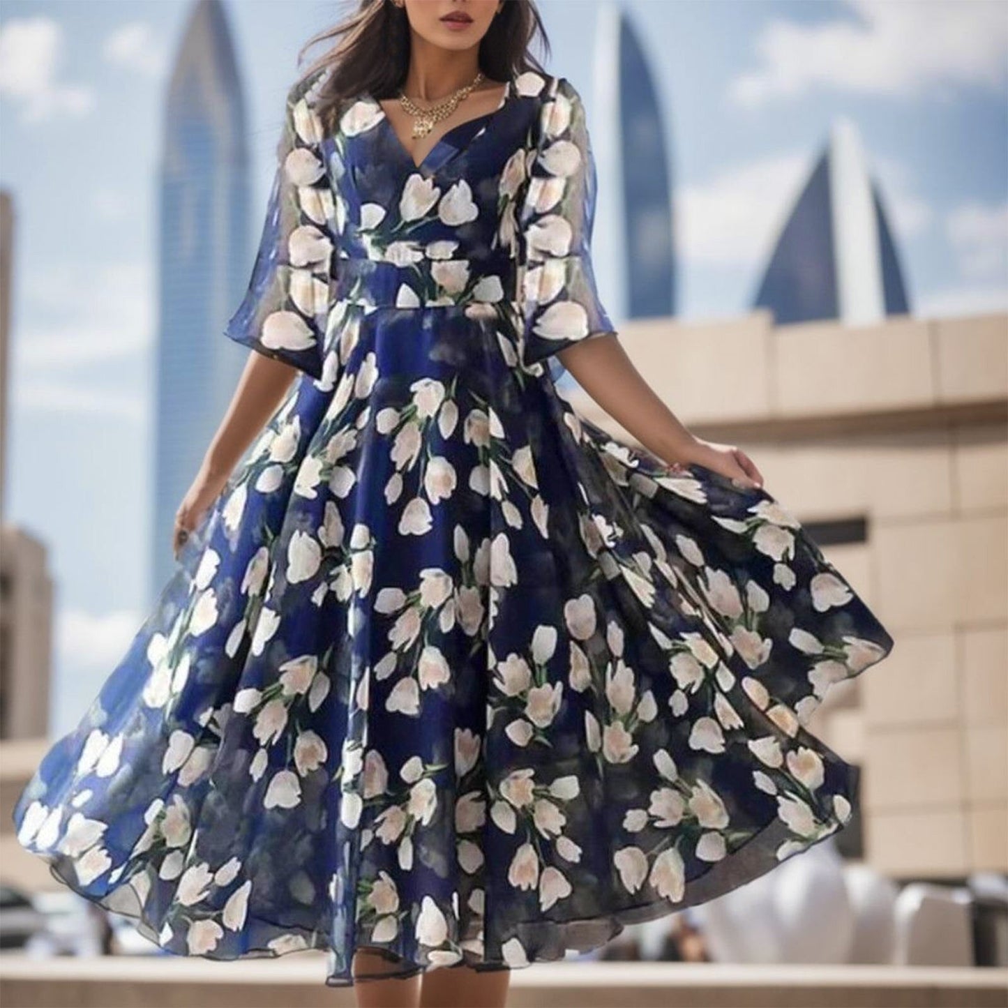 Close-up of a woman wearing a blue floral dress with a flared skirt.