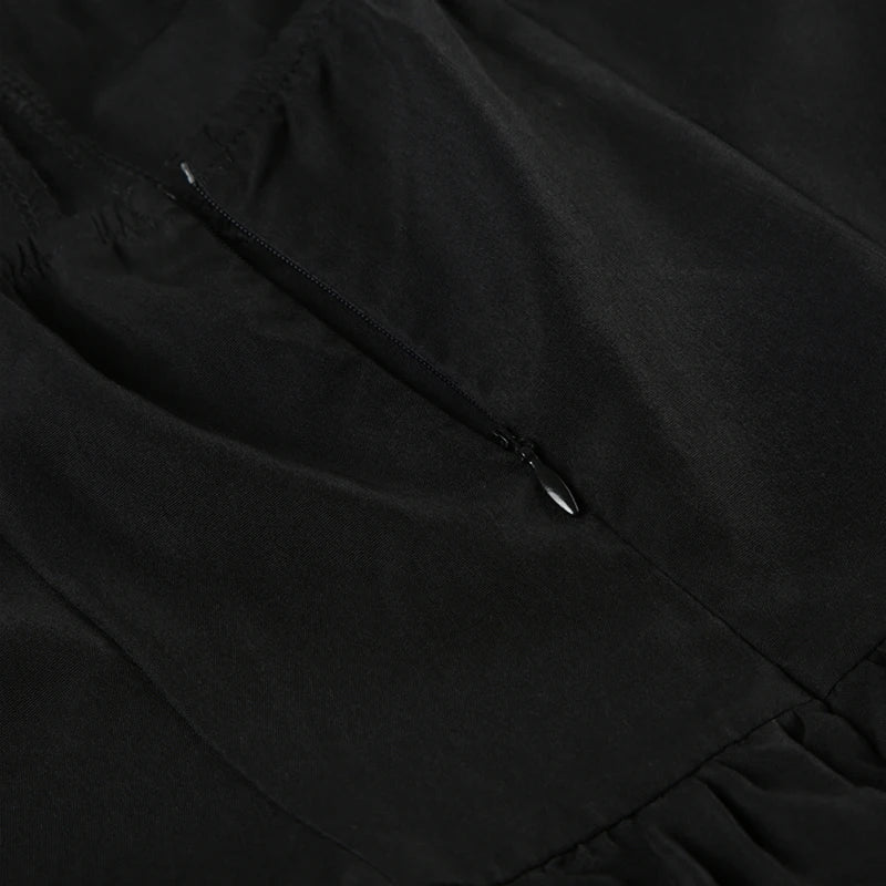 Close-up of the zipper closure on the back of a black dress.