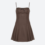 A brown spaghetti strap dress with a black bow and lace trim, shown flat.