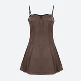 The back of a brown spaghetti strap dress with a black bow and lace trim, shown flat.