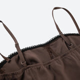 Close-up of the spaghetti straps and lace trim of a brown dress.