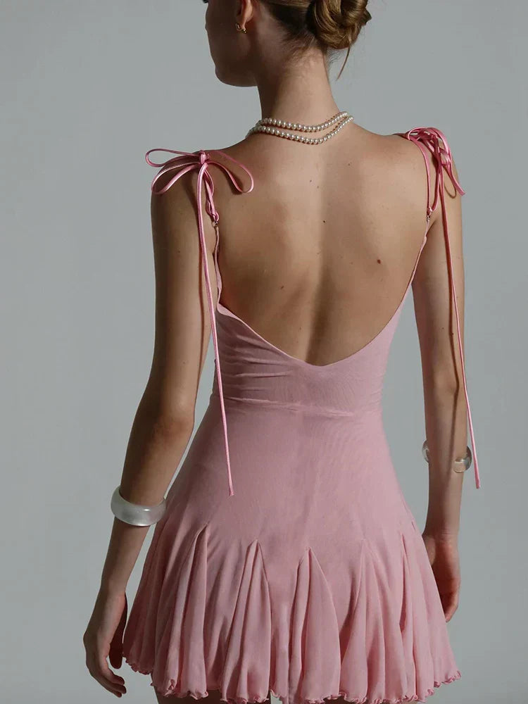 The back of a pink slip dress showing the low back and tie shoulder straps.