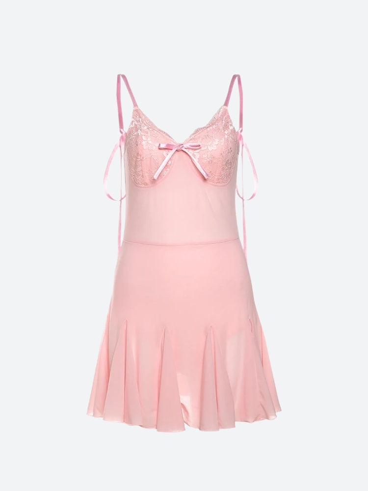 A pink slip dress with lace detailing and a pleated skirt, shown flat.