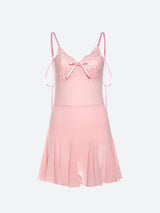 A pink slip dress with lace detailing and a pleated skirt, shown flat.