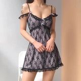 woman wearing a short black lace babydoll dress with pink bow accents
