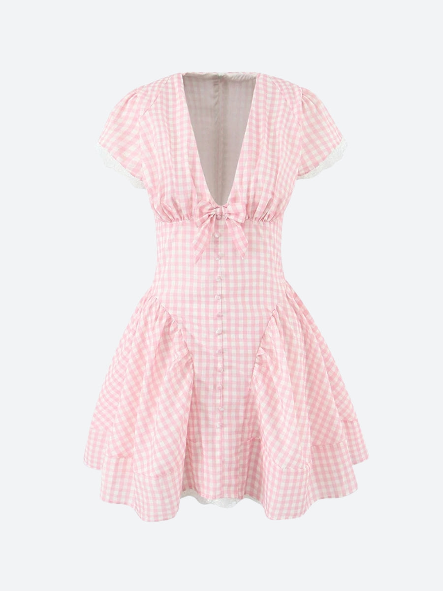 A front view of a pink and white gingham dress with a v-neck, bow, and lace trim.