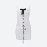 A white corset dress with black lace-up detailing and a black bow, shown against a plain background.