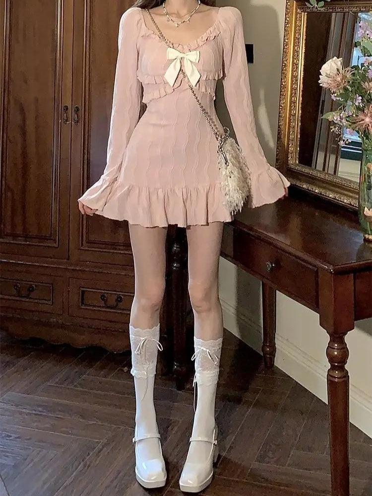 Full body shot of a woman in a pink dress with white socks and shoes.