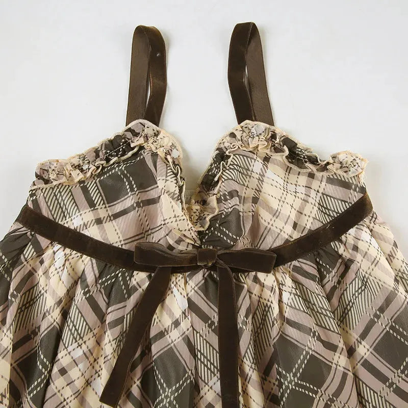 Close-up of the neckline and straps of a plaid babydoll dress with velvet trim.