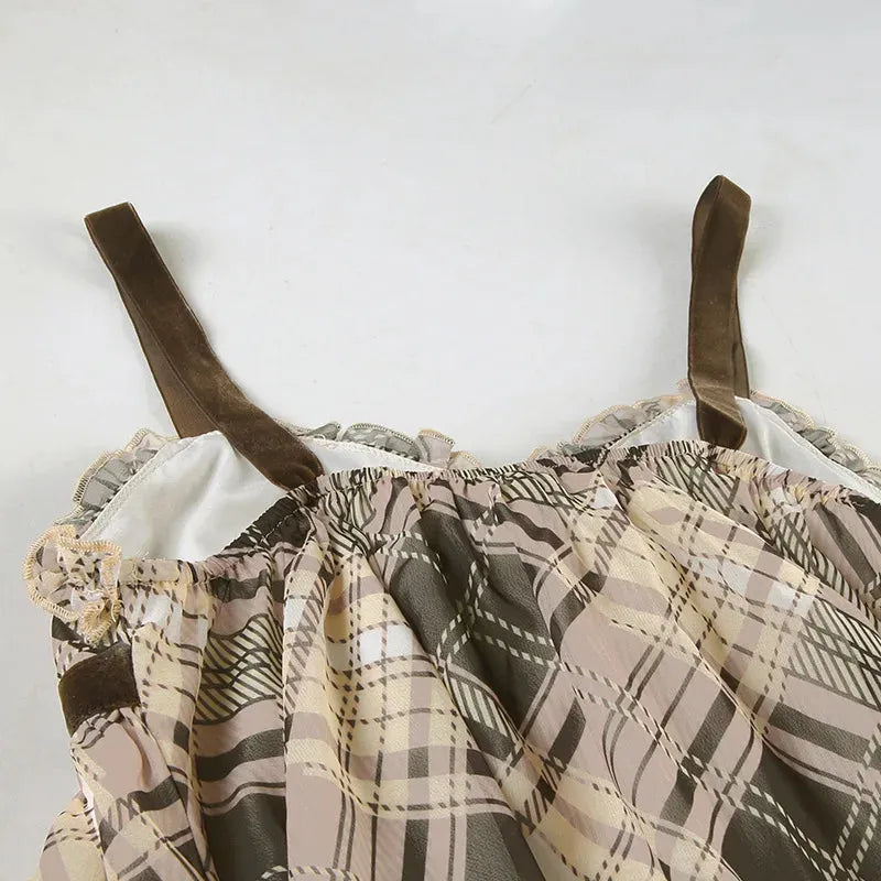 Close-up of the ruffled neckline and velvet straps of a plaid babydoll dress.