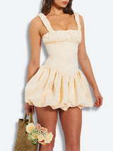 Close-up of the front of the cream mini dress, highlighting the ruched square neckline and the puffy skirt.