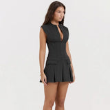 A woman in a dark gray sleeveless mini dress with a plunging V-neck, shown from the side.