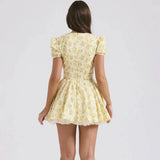 Back view of a woman wearing a yellow floral print mini dress