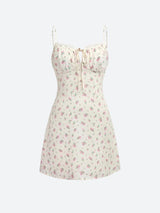 A white floral print mini dress with spaghetti straps and a tie front, displayed on a white background.