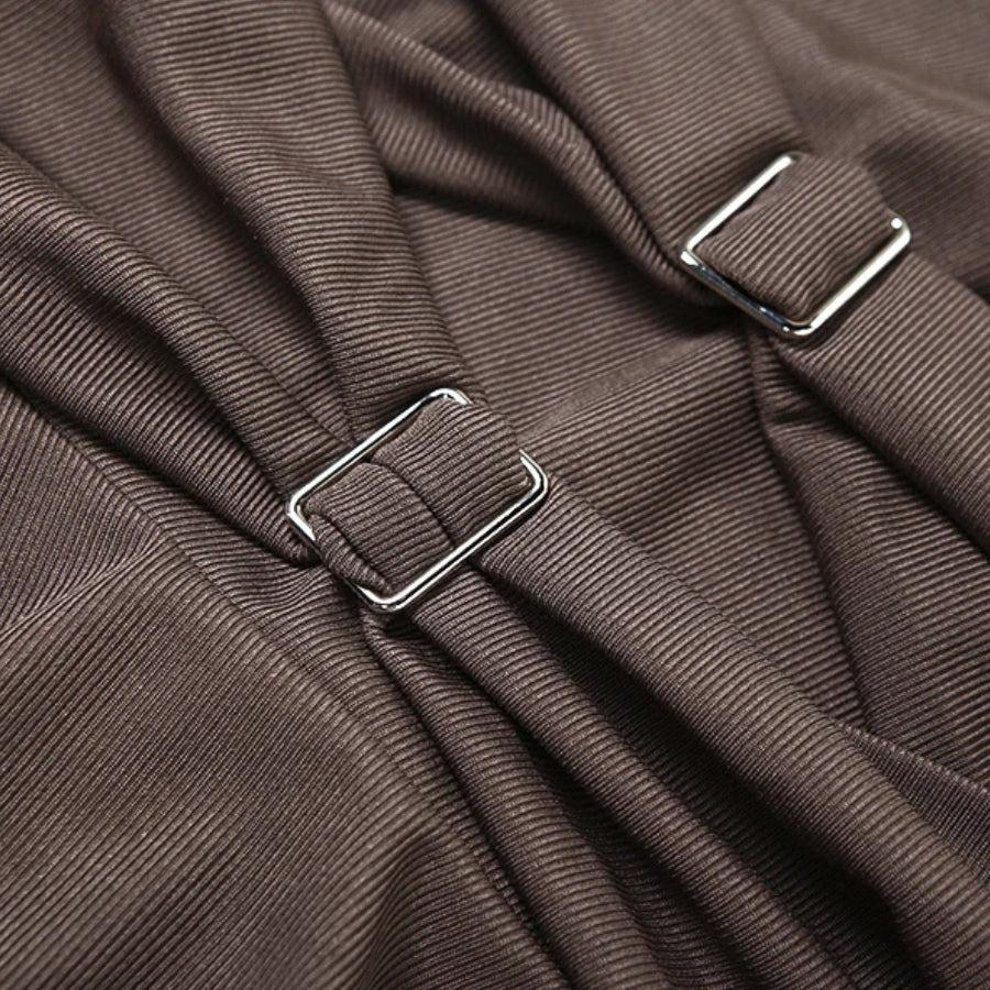 Close-up of the ruched fabric and buckle details on a brown dress.