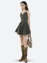 Model wearing a black denim dress with a belt and boots