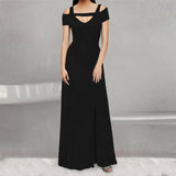 A woman wearing a black floor-length dress with cold shoulder sleeves and a high slit.