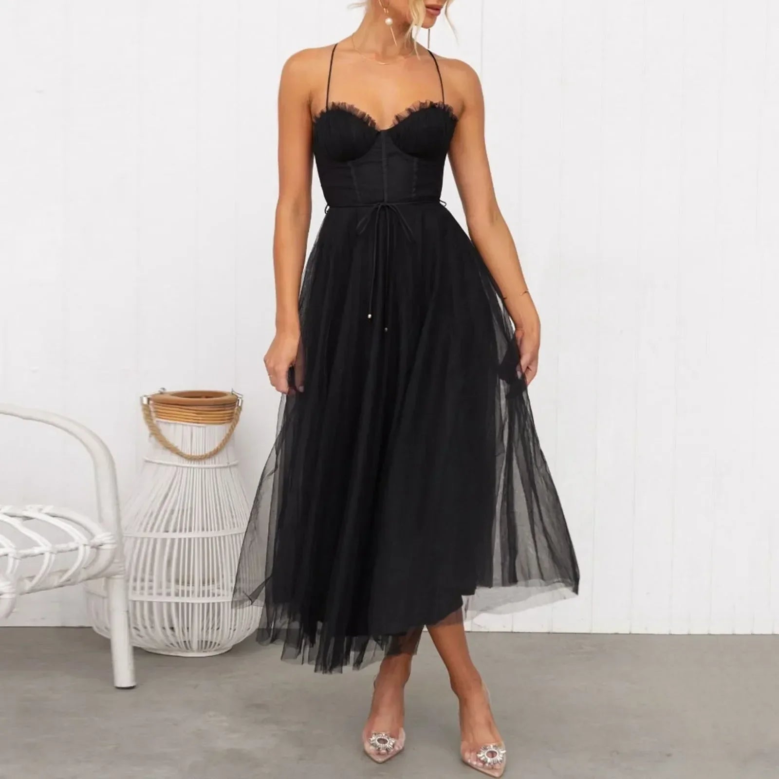 woman in a black midi tulle dress with spaghetti straps and a sweetheart neckline, showing off the skirt