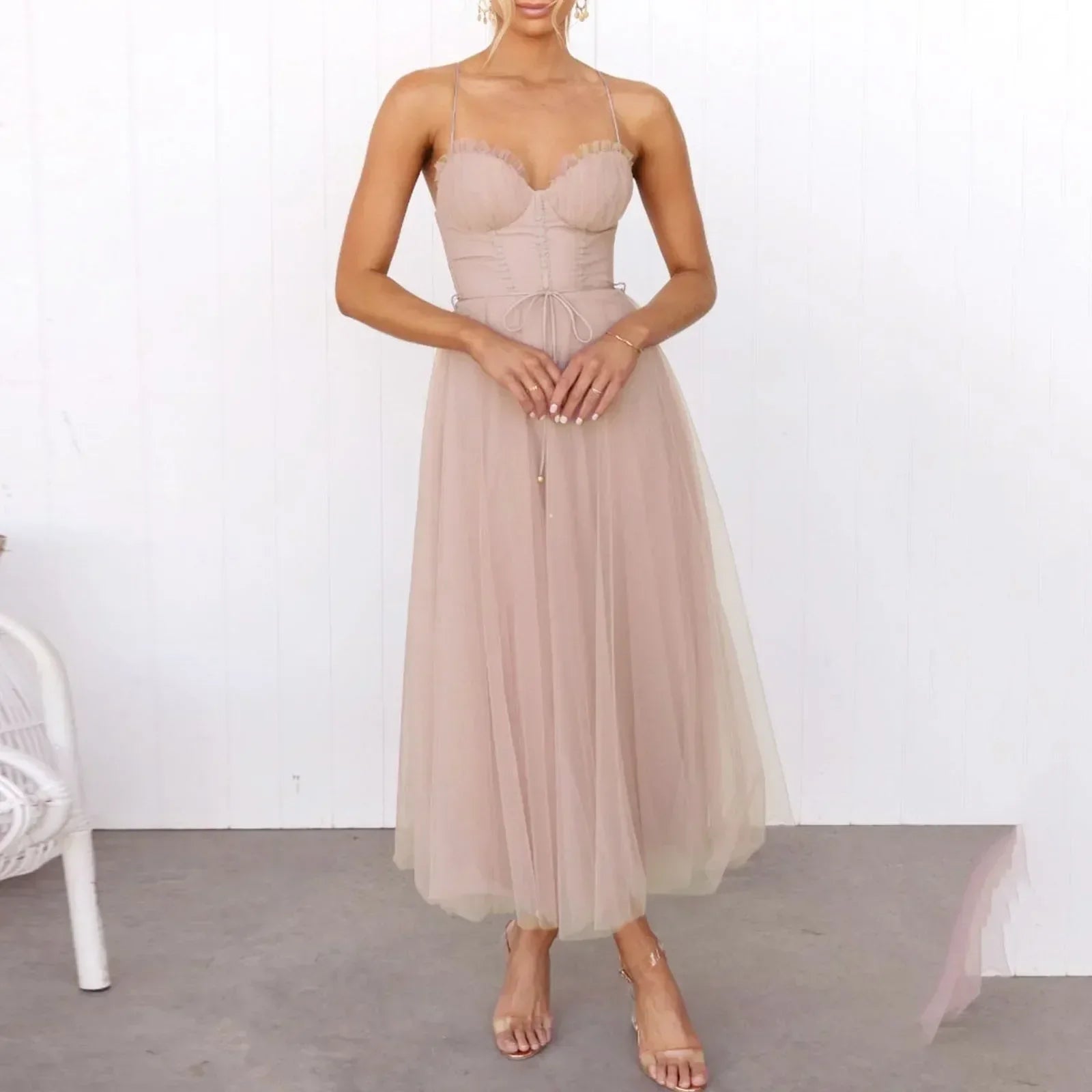 woman in a blush pink midi tulle dress with spaghetti straps and a sweetheart neckline