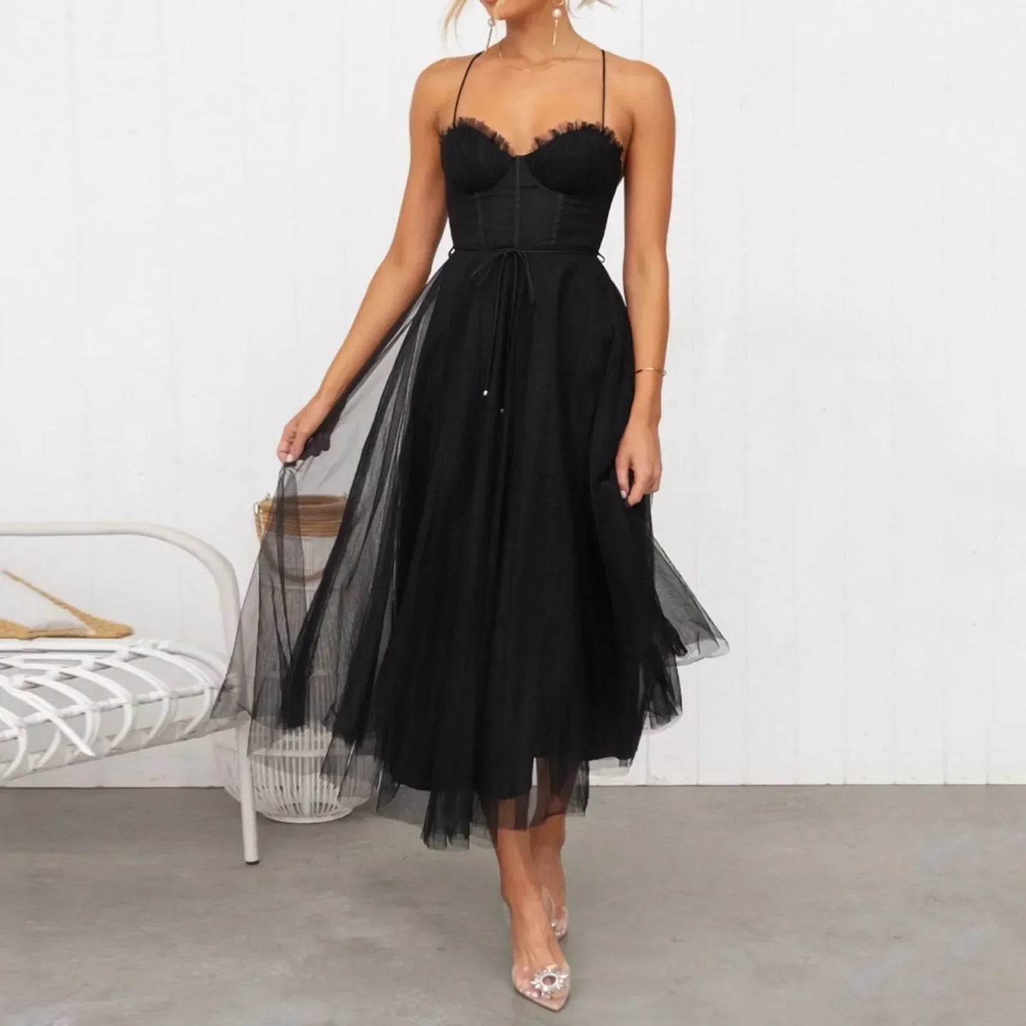 woman in a black midi tulle dress with spaghetti straps and a sweetheart neckline, twirling