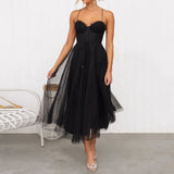 woman in a black midi tulle dress with spaghetti straps and a sweetheart neckline, twirling