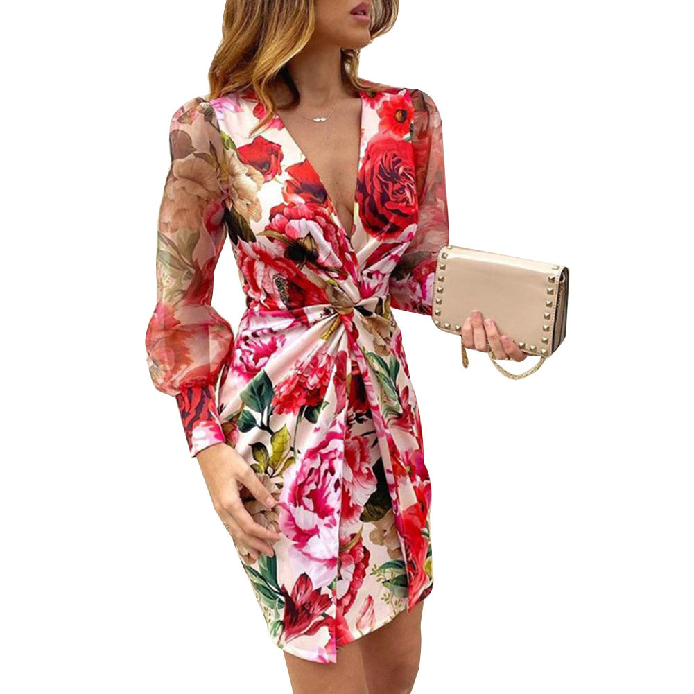 Woman wearing a red floral print dress with sheer sleeves and a plunging v-neck.
