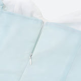 Close-up of the zipper on a light blue dress.
