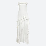 A white strapless ruffled maxi dress with an asymmetrical hem and tiered ruffles on the skirt.