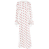 White polka dot maxi dress with red polka dots and long bell sleeves.